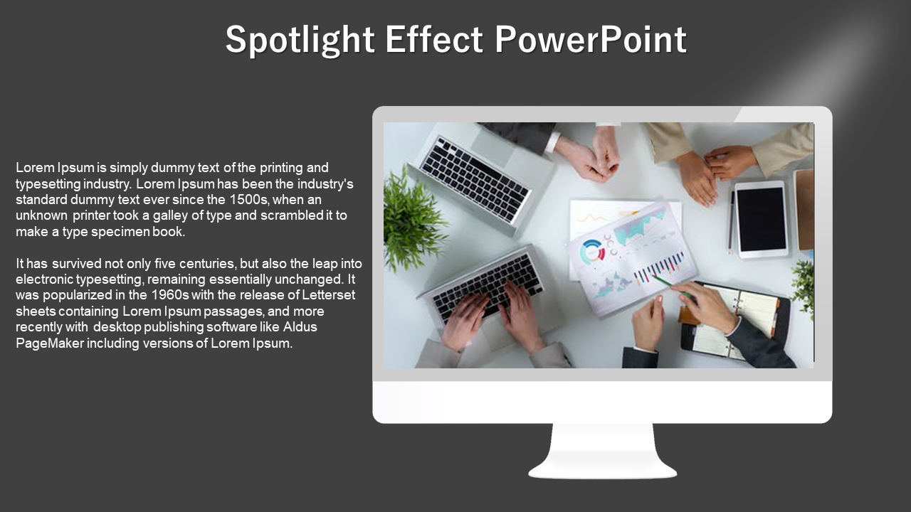 Computer monitor under spotlights shows a team working with laptops and charts and text on the left, against a gray backdrop.