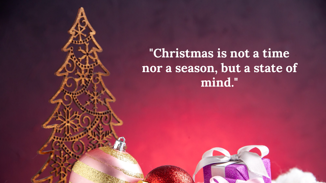 A wooden Christmas tree decoration with a pink and gold ornament, featuring the quote.