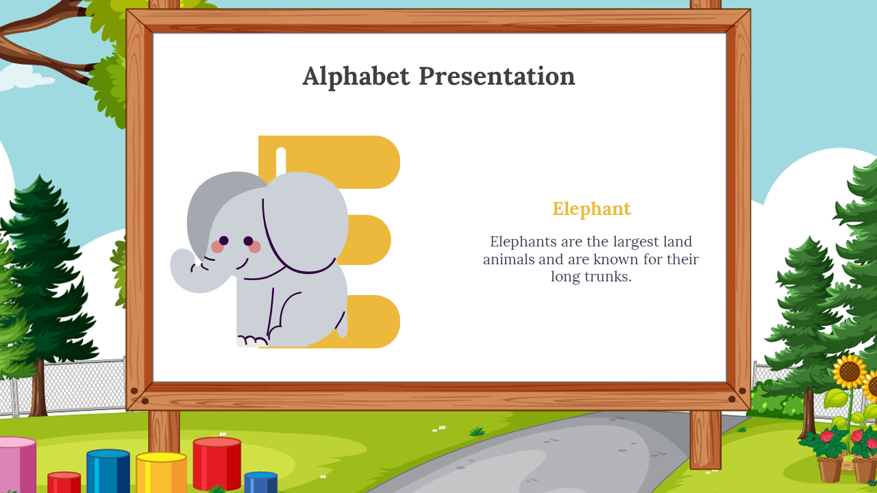 Playful gray elephant cuddled to a yellow E on a framed whiteboard, and background showing trees, blocks, and blue sky.