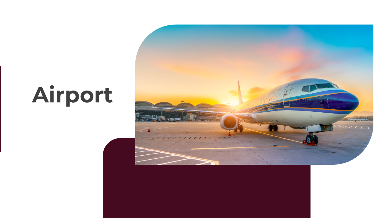An airplane on the tarmac at an airport with a colorful sunset sky in the background.