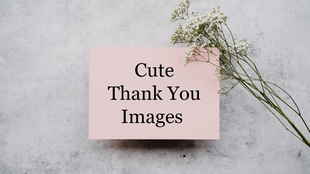Pink card with the text area for a cute thank you message placed on a gray surface with a sprig of small white flowers.