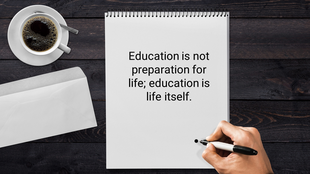 Desktop scene with a motivational education quote written on a notepad, a hand adding a dot, and a coffee cup nearby.